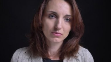 Portre orta yaşlı esmer beyaz kadın sefil izliyor ve ne yazık ki içine kamera siyah arka plan üzerine.