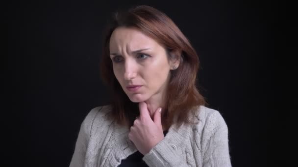 Retrato de mujer caucásica morena de mediana edad con terrible dolor de garganta sobre fondo negro . — Vídeos de Stock