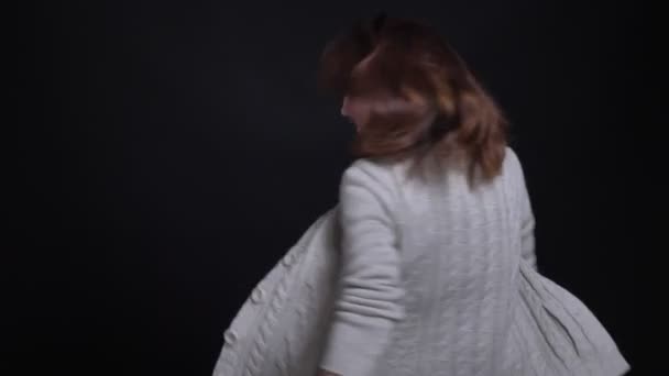 Porträtt av medelålders brunett kaukasiska kvinna snurrar runt och bättrade finger upp skyltar till kameran på svart bakgrund. — Stockvideo