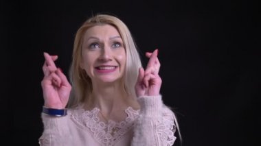 Beyaz kadın onun parmak anksiyete ve gülümseyen ve kameraya bakarak umut çarpı işareti olan orta portre çekimleri yaşlı