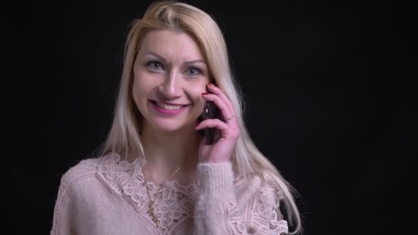 Closeup πυροβολούν της μέσης ηλικίας καυκάσιος γυναίκα με ξανθά μαλλιά, έχοντας μια περιστασιακή συνομιλία σχετικά με το τηλέφωνο — Αρχείο Βίντεο