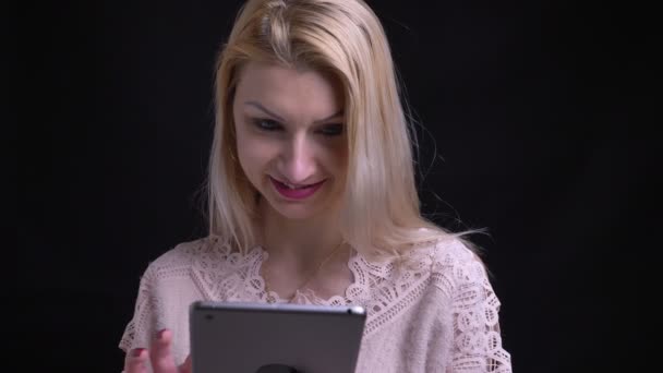 特写镜头拍摄的中年高加索女性使用平板电脑, 然后看着相机和微笑 — 图库视频影像