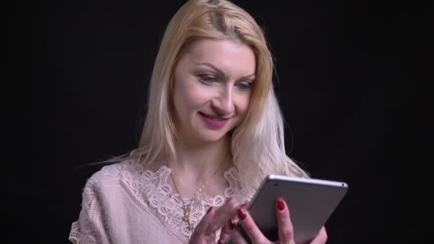 特写镜头拍摄的成人高加索金发女郎使用平板电脑, 并显示绿色屏幕手势拇指和微笑在镜头前 — 图库视频影像