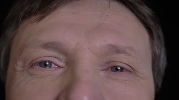 Πυροβολούν closeup της μέσης ηλικίας Καυκάσιος ανδρικό πρόσωπο με γκρι μάτια κοιτώντας ευθεία σε φωτογραφική μηχανή με χαμογελαστό έκφραση του προσώπου — Αρχείο Βίντεο