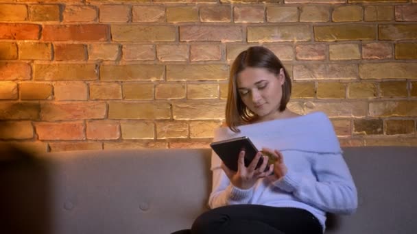 Vértes-lő a fiatal kaukázusi nő segítségével a tabletta, és bemutatja a zöld chroma-kulcs képernyő-kamera mosolygós — Stock videók