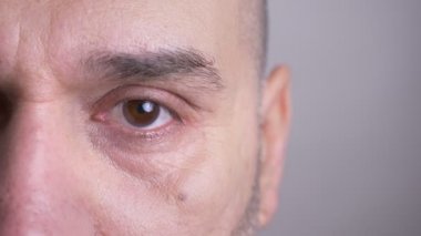 Orta yaşlı beyaz adam izole arka plan ile doğrudan kameraya bakan closeup yarı-yüz portresi