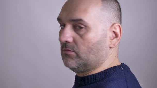 Closeup shoot of middle-aged caucasian man turning to the camera and looking forward with emotionless facial expression — Stock Video