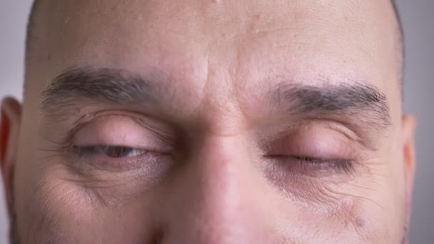 Closeup πυροβολούν μέσης ηλικίας Καυκάσιος αρσενικό πρόσωπο με καστανά μάτια, κοιτάζοντας κατευθείαν σε κάμερα με απομονωμένες φόντο — Αρχείο Βίντεο