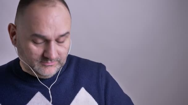 Primer plano del hombre caucásico de mediana edad escuchando música en las vibraciones y cantando alegremente — Vídeos de Stock