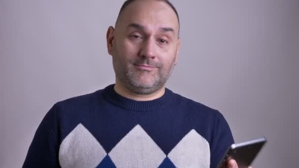 Крупним планом портрет дорослого кавказького чоловіка, який використовує планшет і показує зелений екран на камеру посміхаючись — стокове відео
