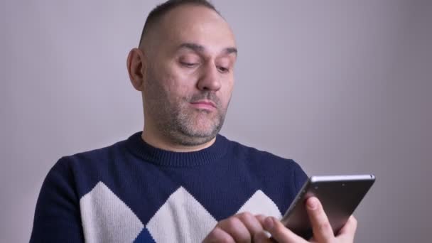 Πυροβολούν closeup της μέσης ηλικίας Καυκάσιοι άνδρες χρησιμοποιώντας το tablet και δείχνοντας πράσινο chroma κλειδί οθόνη με διαφήμιση πάνω σε φωτογραφική μηχανή χαμογελώντας — Αρχείο Βίντεο