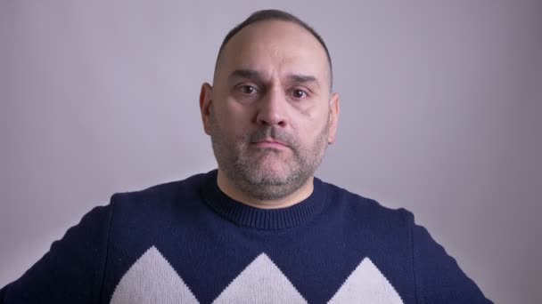 Съемка крупным планом взрослого кавказца, хлопающего головой рукой, смущенного и неловкого перед камерой — стоковое видео