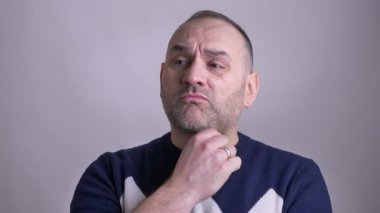 Orta portre çekimleri yaşlı beyaz adam düşünceli bir fikir almak ve kameraya bakarak gülen olmak