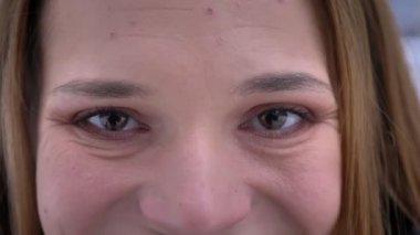 Doğruca kameraya gülümseyen yüz ifadesi ile seyir kahverengi gözlü genç oldukça beyaz kadın yüzü closeup portresi