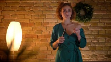 Sinirli Tv izlerken ve rahat ev arka plan üzerinde elleriyle yüzünü gizleme gözlüklü zencefil kıvırcık saçlı beyaz kız portresi.