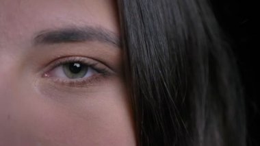 Doğruca kameraya bakarak yeşil gözlü genç çekici beyaz kadın portre yarı-yüz portresi