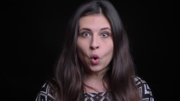 Close-up tiro de jovem bela mulher caucasiana ficando surpreso e animado na frente da câmera com fundo isolado no preto — Vídeo de Stock