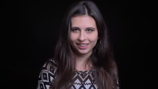 Closeup portrait of young pretty cheerful caucasian female turning around with her hair fluttering looking at camera and smiling — Stock Video