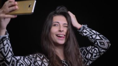 Telefon gülümseyen üzerinde selfies alarak ve kamera önünde poz genç oldukça beyaz kadın portresi portre