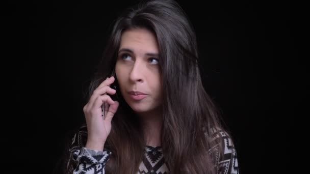 Крупный план съемки молодой привлекательной кавказской женщины, беседующей по телефону перед камерой — стоковое видео