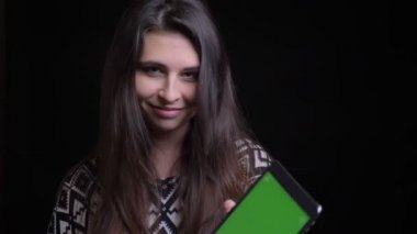 Closeup ateş tablet kullanma ve yeşil renk ekran kamera gülümseyen için gösterilen genç çekici beyaz kadın