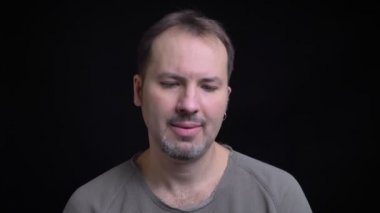 Portresi orta yaşlı beyaz adam baş olumsuz kamera siyah arka plan üzerine dönüşüyor Küpeli konsantre.