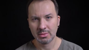 Yakın çekim portre fotoğraf makinesi siyah arka plan üzerine gizli saldırganlık ile içine izlerken Küpeli orta yaşlı beyaz adamın.