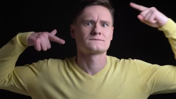 Retrato de homem caucasiano de meia-idade em suéter amarelo dançando ativamente à música em fundo preto . — Vídeo de Stock