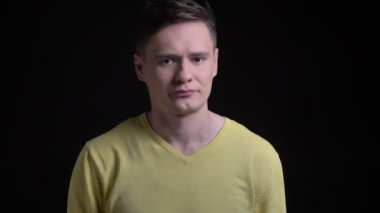 Orta yaşlı beyaz adam sarı kazaklı facepalm işareti tahriş kamera içine siyah arka plan üzerine göstermek için el hareketi.