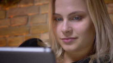 Portre portre rahat evde kapalı tablet tarama sarı saçlı genç kadın
