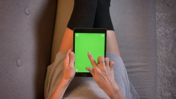 Sesión de primer plano de influencer de redes sociales de moda seductora utilizando la tableta con pantalla verde. Mujeres muslos en calcetines lindos en el sofá — Vídeo de stock