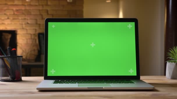 Closeup schieten van de laptop met groene scherm met promotie op het op het Bureau in het kantoor binnen op de werkplek — Stockvideo