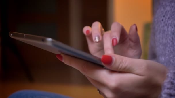 Closeup střílet z ženských rukou, psaní na tabletu v útulném bytě uvnitř — Stock video