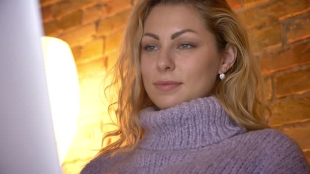 Närbild sidovy skjuta av vuxen kaukasiska attraktiv kvinna att skriva på den bärbara datorn inomhus i en mysig lägenhet — Stockvideo