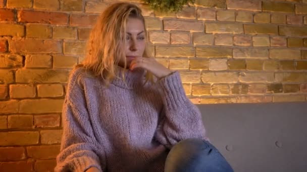 Närbild skjuta av vuxen kaukasiska blond kvinna titta på Tv att bli rörd och ledsen gråter medan du sitter i soffan inomhus på mysiga hem — Stockvideo