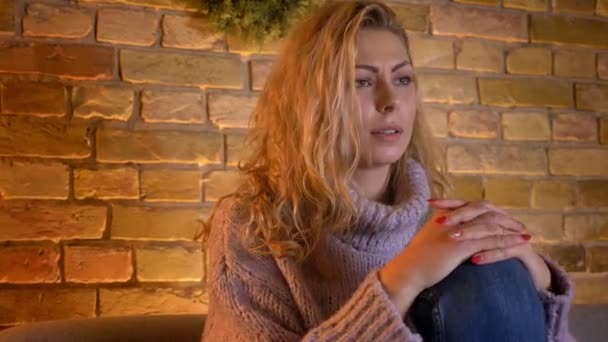 Gros plan shoot de adulte caucasien blonde femelle regarder la télévision film d'horreur et obtenir un jumpscare à la maison confortable à l'intérieur — Video