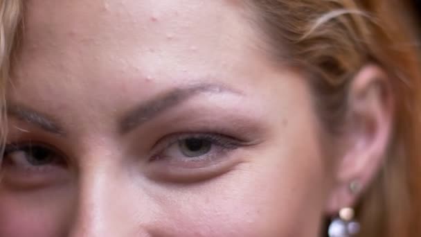 Съемка крупным планом взрослого привлекательного белокурого кавказского женского лица с глазами, соблазнительно смотрящими в камеру на боке-фоне — стоковое видео