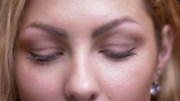 Close-up tiro de adulto atraente loira caucasiano feminino rosto com olhos sendo fechado e abertura e olhando em linha reta para a câmera — Vídeo de Stock