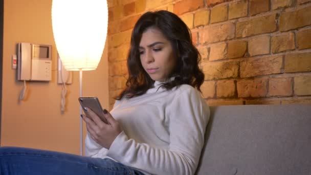 Ritratto di profilo di attraente donna d'affari caucasica bruna che lavora con smartphone si rivolge alla fotocamera in atmosfera domestica . — Video Stock