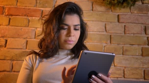 Hermosa mujer de negocios caucásica que trabaja con la tableta se convierte en cámara y mira sonriendo en el ambiente del hogar . — Vídeo de stock