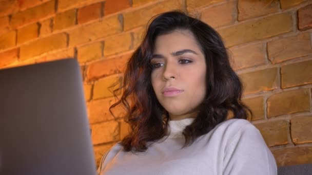 Närbild porträtt i profil av uppmärksam kaukasiska brunett affärs kvinna sitter på soffan och arbeta med laptop hemma. — Stockvideo
