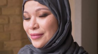 Tesettür kamera bakıyor ve işyerinde mutlu kapalı gülümsüyor yetişkin Müslüman başarılı kadın çalışanın closeup ateş