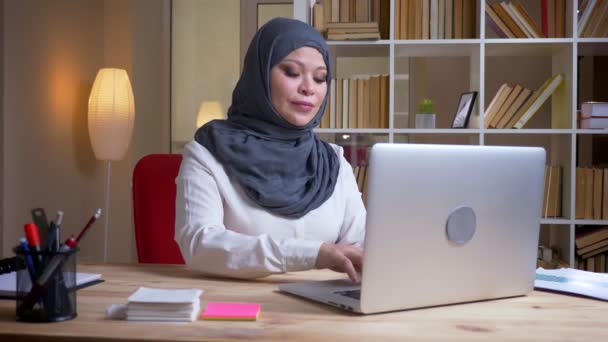 Syuting tertutup dari muslim dewasa sukses perempuan pekerja kantor mengetik di laptop tersenyum bahagia di dalam ruangan — Stok Video