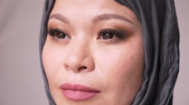 Olgun çekici Müslüman kadın hijab ileriye bakarak ve izole arka plan ile kamera dönüm closeup ateş
