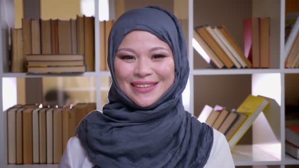 Syuting tertutup dari muslim dewasa pengusaha melihat kamera dan tersenyum bahagia berdiri di perpustakaan di tempat kerja di dalam ruangan — Stok Video