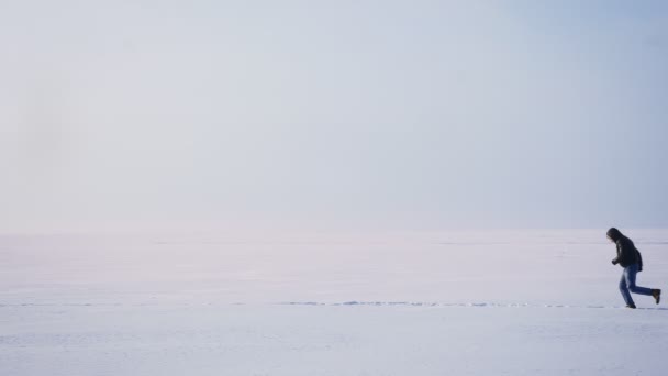 广泛的拍摄男性剪影在外形在雪上快速左板奔跑. — 图库视频影像