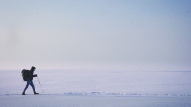 Profil, kar üzerinde yürüyün yürüyüş erkek Backpacker siluet geniş çekim.