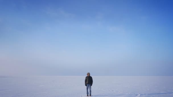 在雪沙漠背景下, 中年探险家平静而严肃地观看镜头的缩放. — 图库视频影像