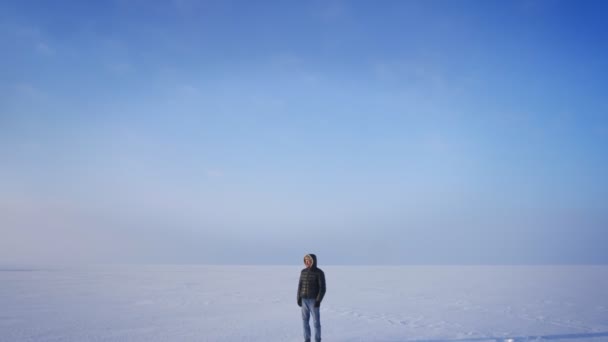 Acercamiento en la toma de explorador de mediana edad mirando sonriente en la cámara en el fondo desierto de nieve . — Vídeo de stock