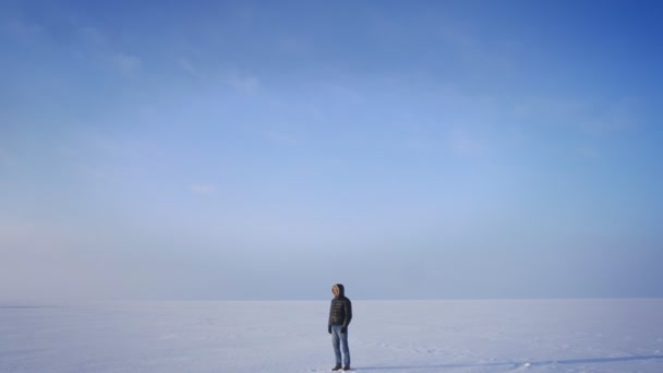 Acercamiento en la toma de explorador de mediana edad se convierte en cámara y sonríe en él en el fondo del desierto de nieve . — Vídeos de Stock